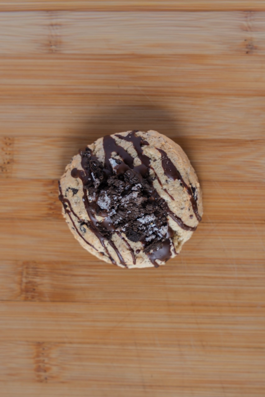 Cookies-and-cream cookie topped with crushed Oreo and dark chocolate drizzle